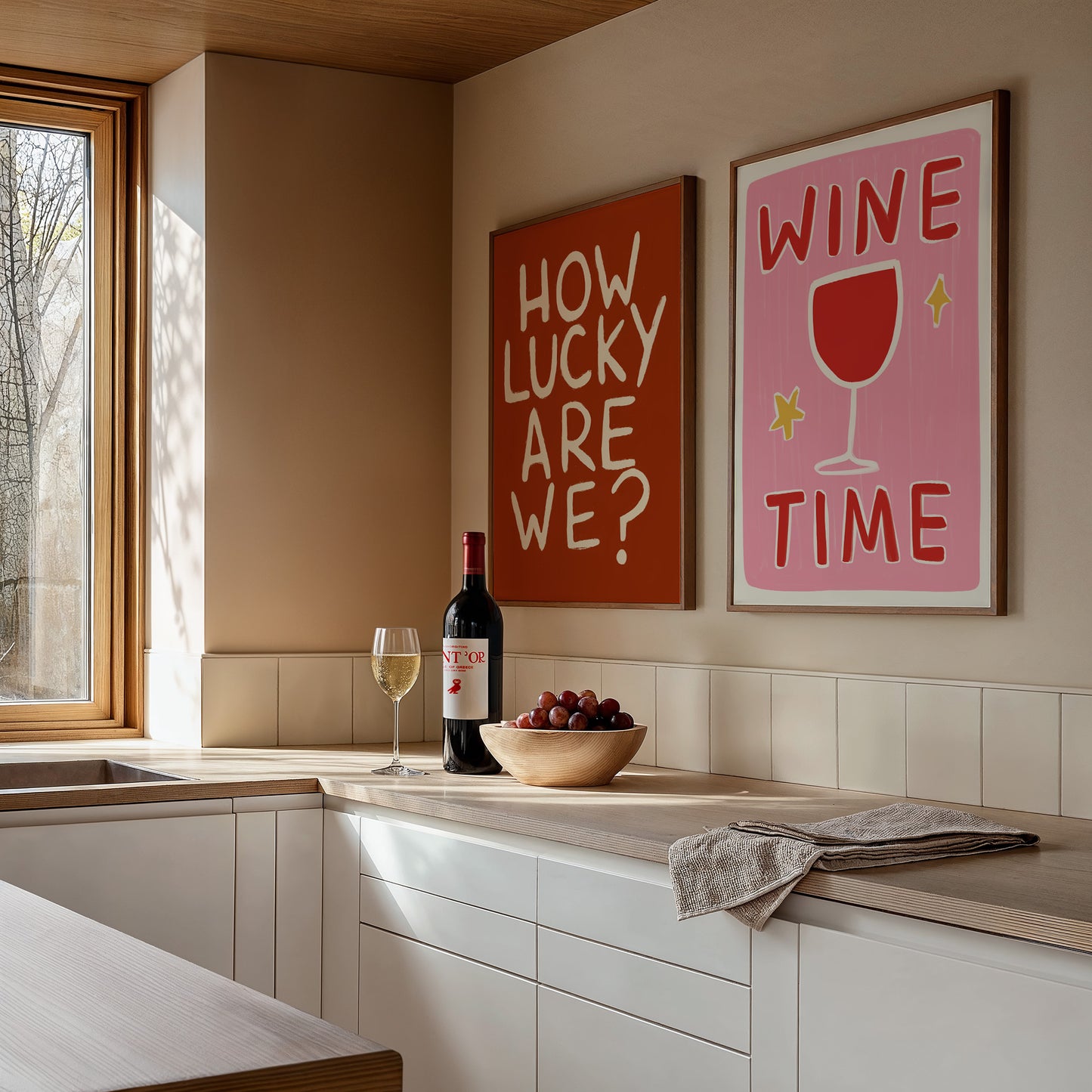 Modern kitchen with wine bottle, glasses, and decorative signs on the wall.