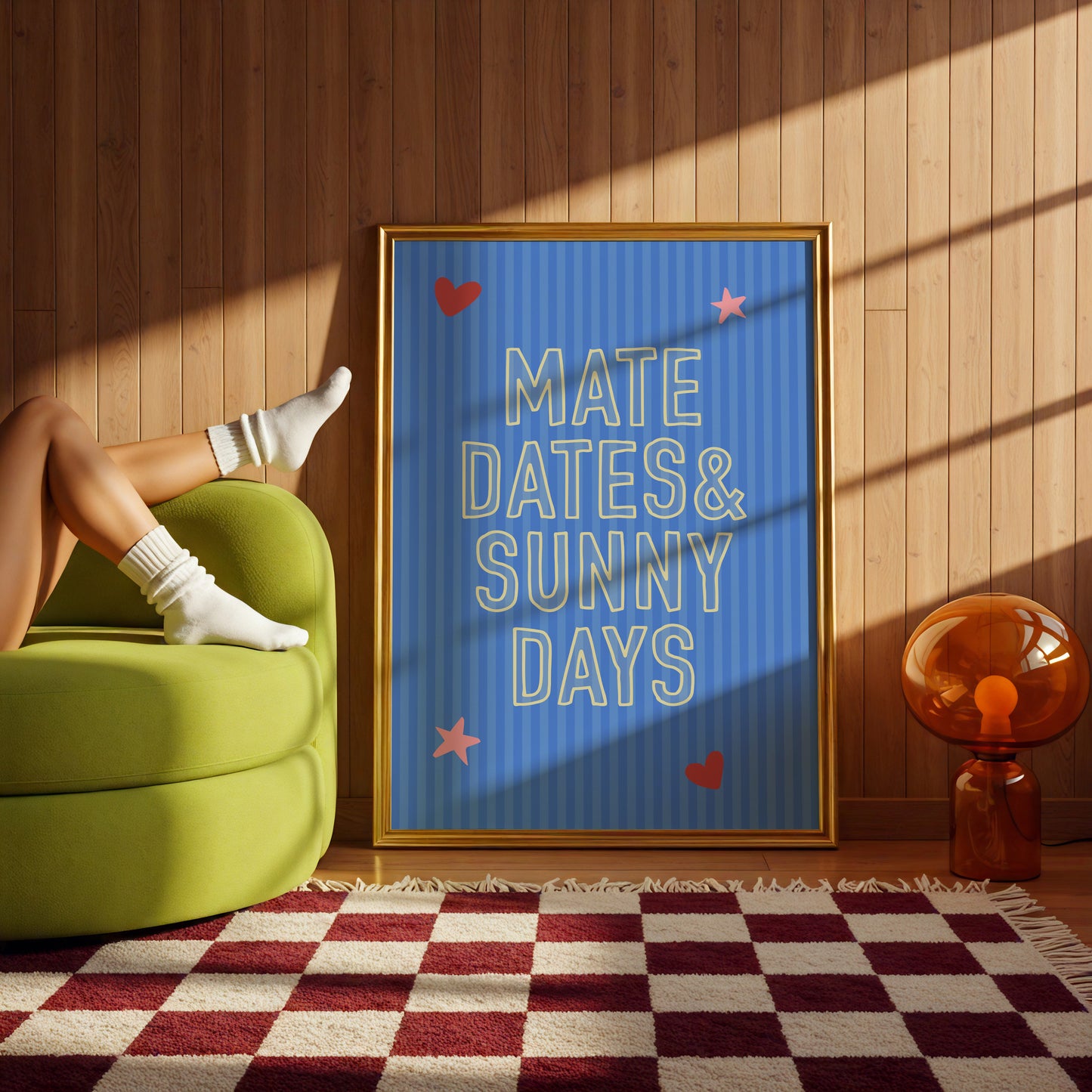 Person sitting on a green chair with a framed quote 'MATE DATES & SUNNY DAYS' in a room with wooden walls and a checkered rug.