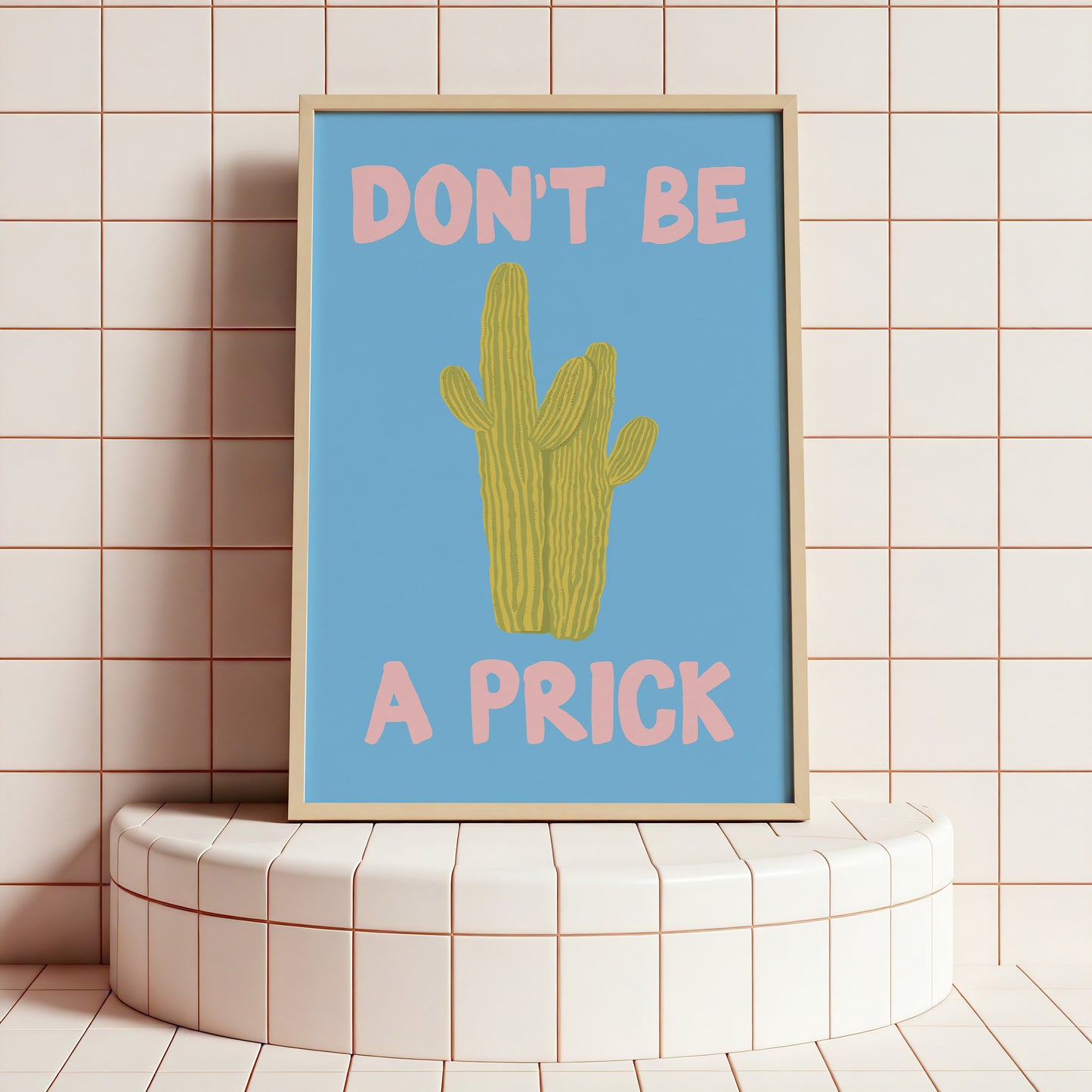 Framed poster with a cactus illustration and text on a tiled wall.