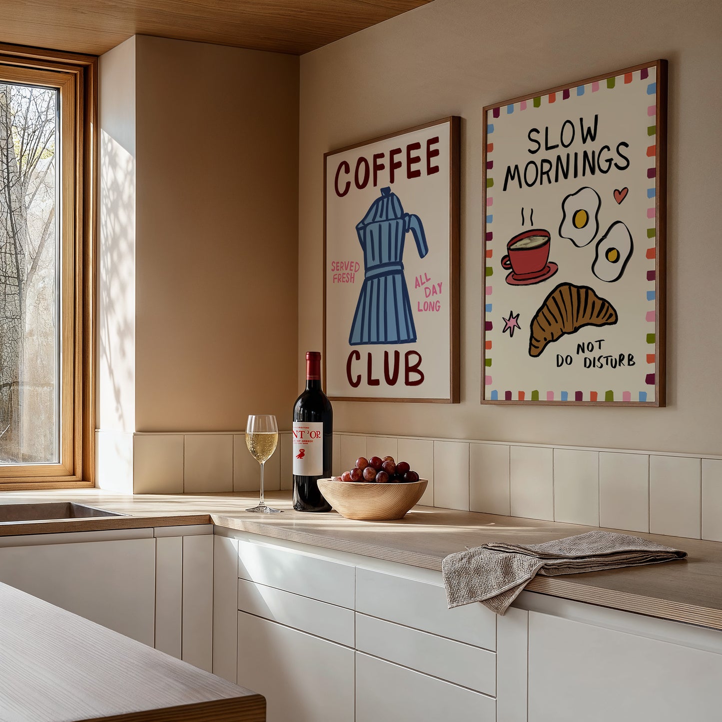 Modern kitchen with coffee-themed wall art and wine on a countertop.