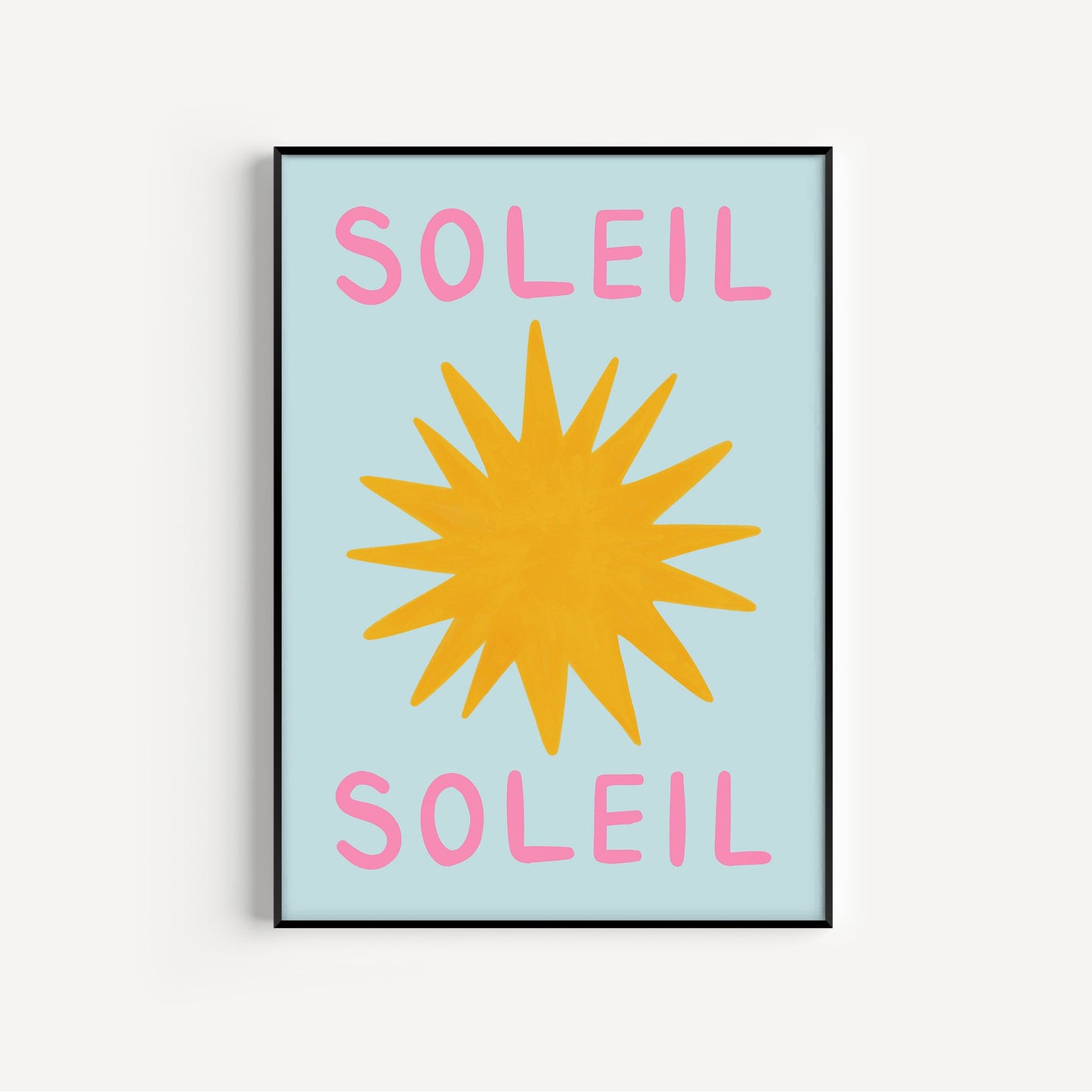 Framed artwork with a yellow sun and pink 'Soleil' text on a light blue background