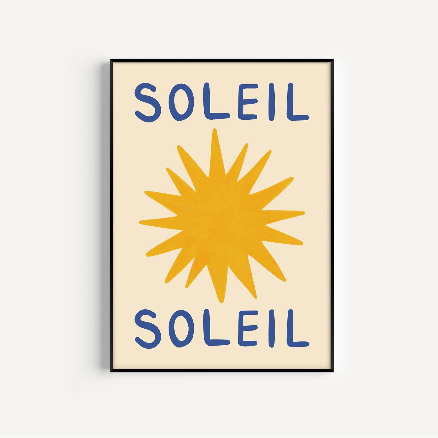 Framed artwork with a yellow sun and blue text spelling 'Soleil' on a beige background