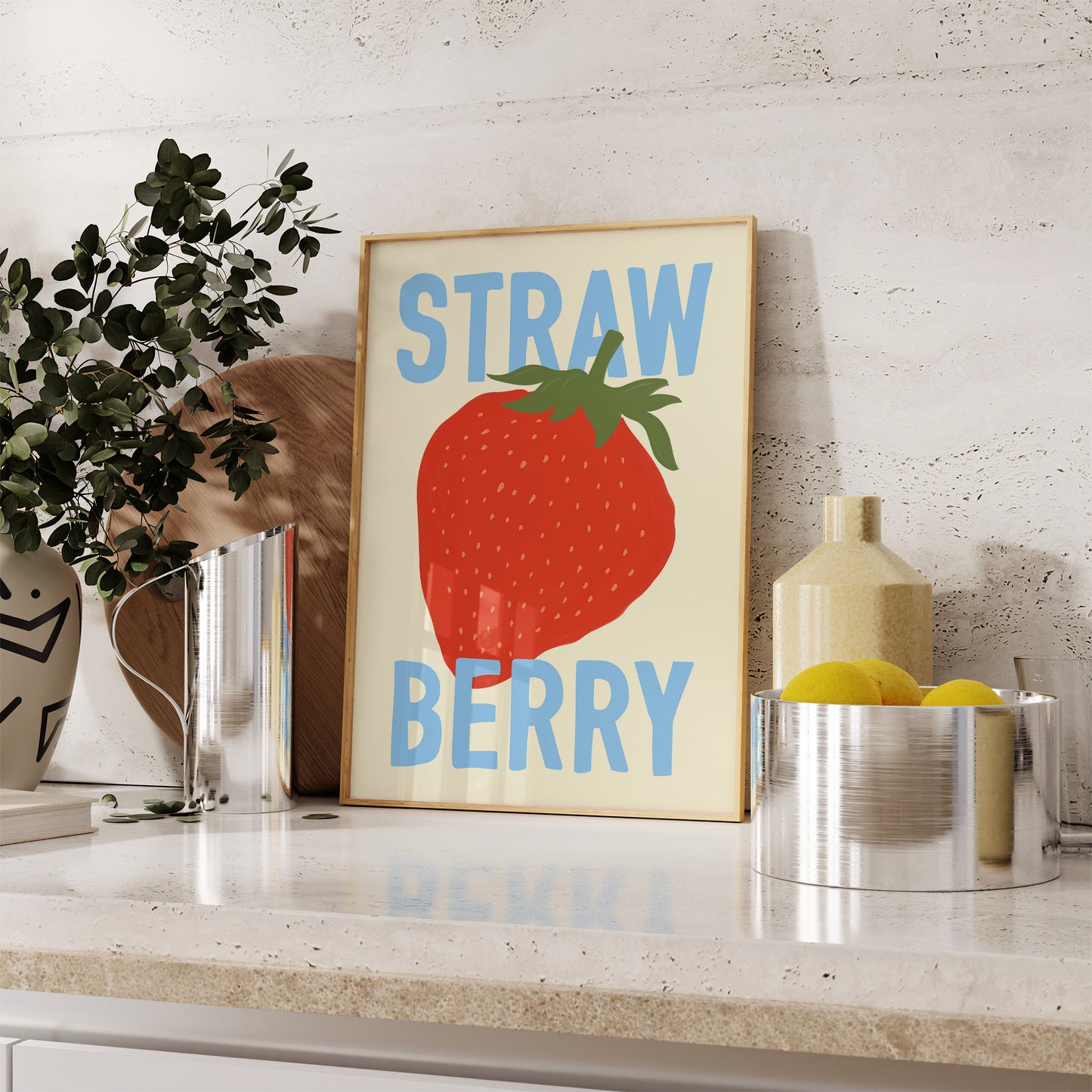 Framed artwork with a strawberry illustration and 'Strawberry' text on a shelf.