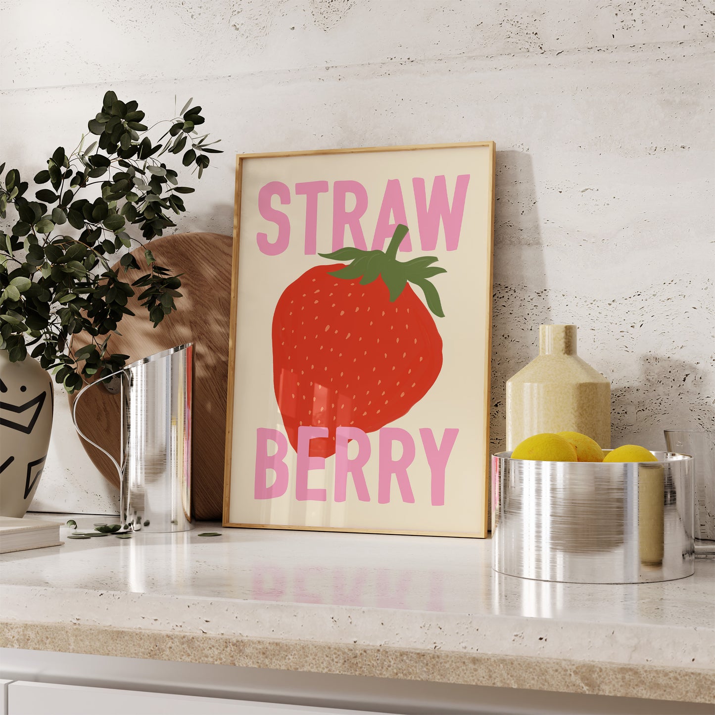 Framed artwork of a strawberry with 'Strawberry' text on a shelf with decorative items.