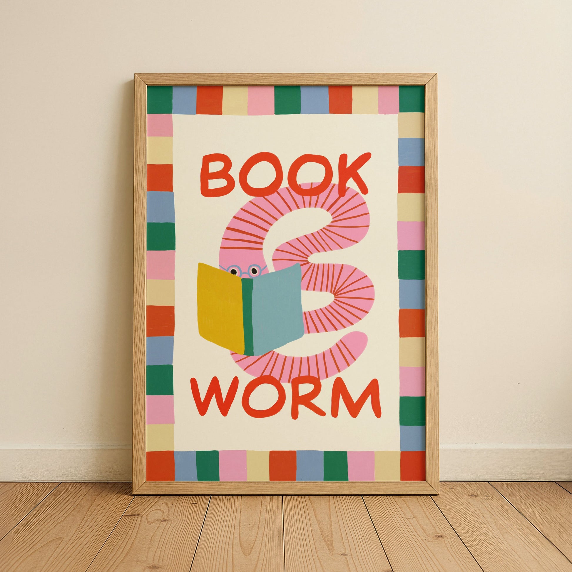 Framed artwork with a colorful worm reading a book design on a beige wall.