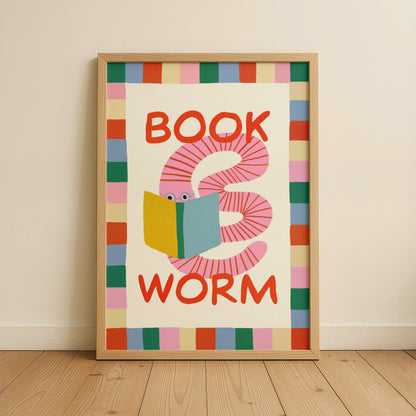 Framed artwork with a colorful worm reading a book design on a beige wall.