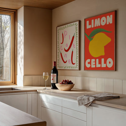 Modern kitchen with wine bottle, glass, and fruit on a countertop, featuring two colorful artworks on the wall.