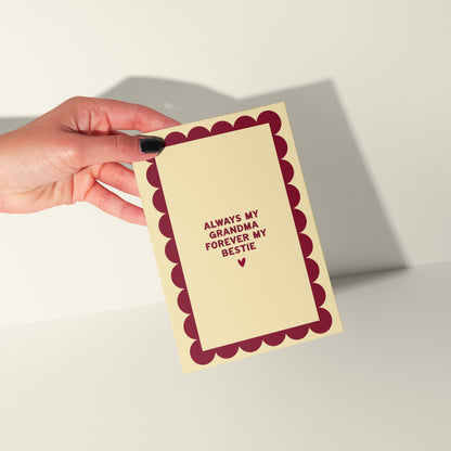 Hand holding a card with text 'Always my mum, forever my bestie' on a plain background