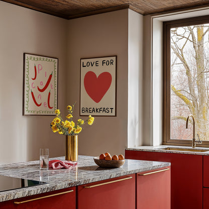 Modern kitchen with red cabinets, marble countertop, and decorative wall art.