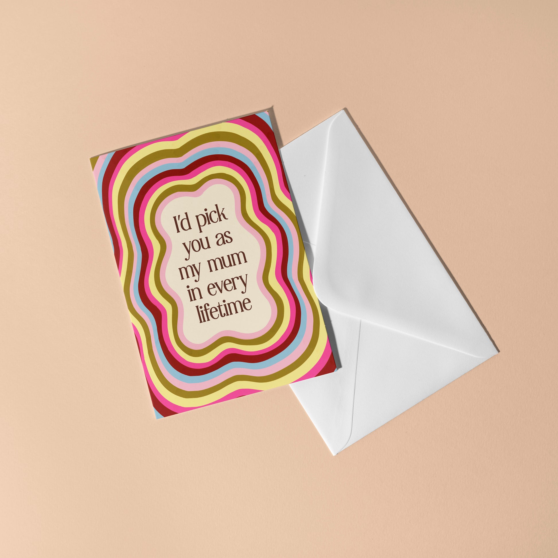 Greeting card with colorful design and text, accompanied by a white envelope on a beige background.