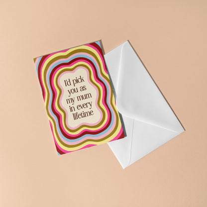 Greeting card with colorful design and text, accompanied by a white envelope on a beige background.