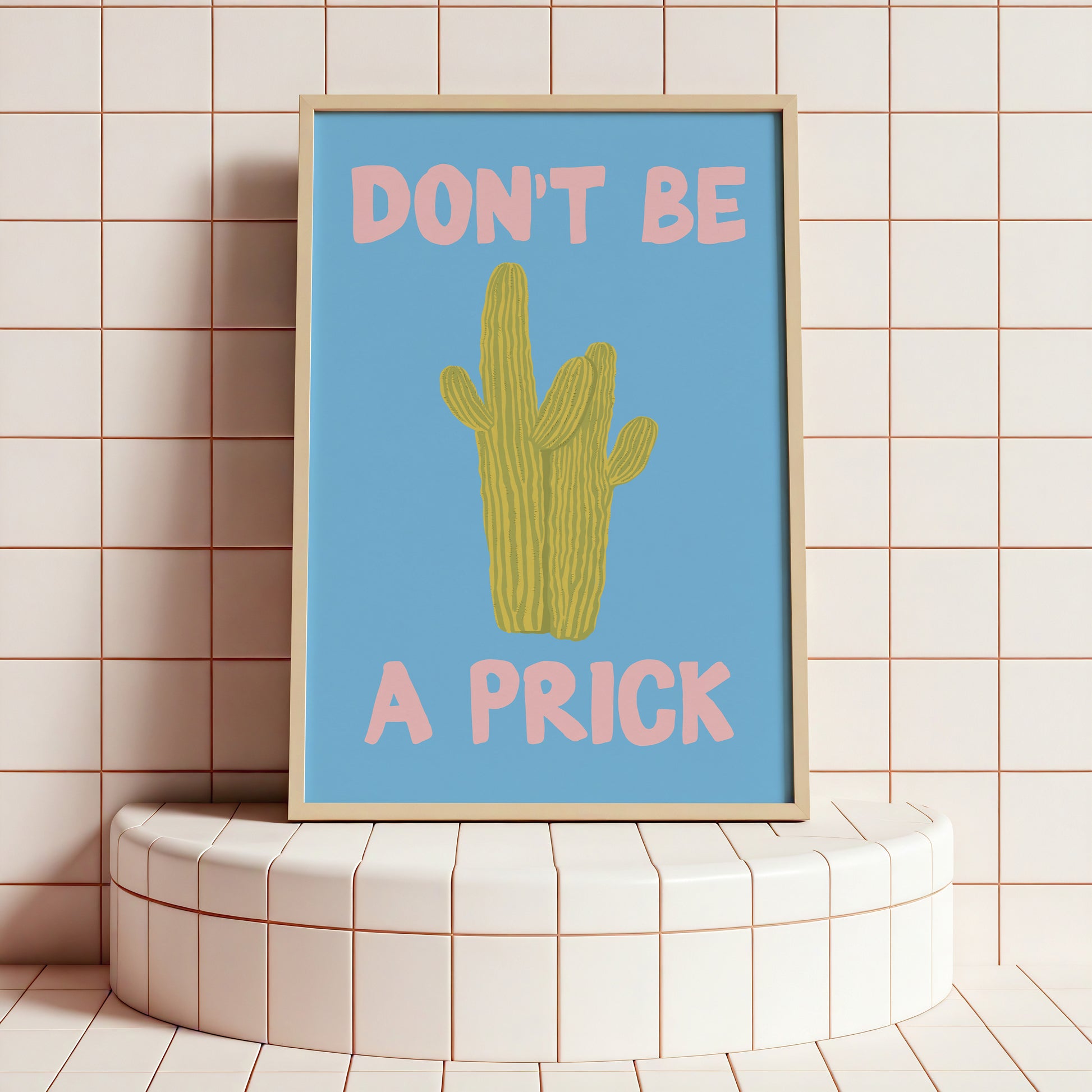 Framed poster with a cactus illustration and text on a tiled wall.